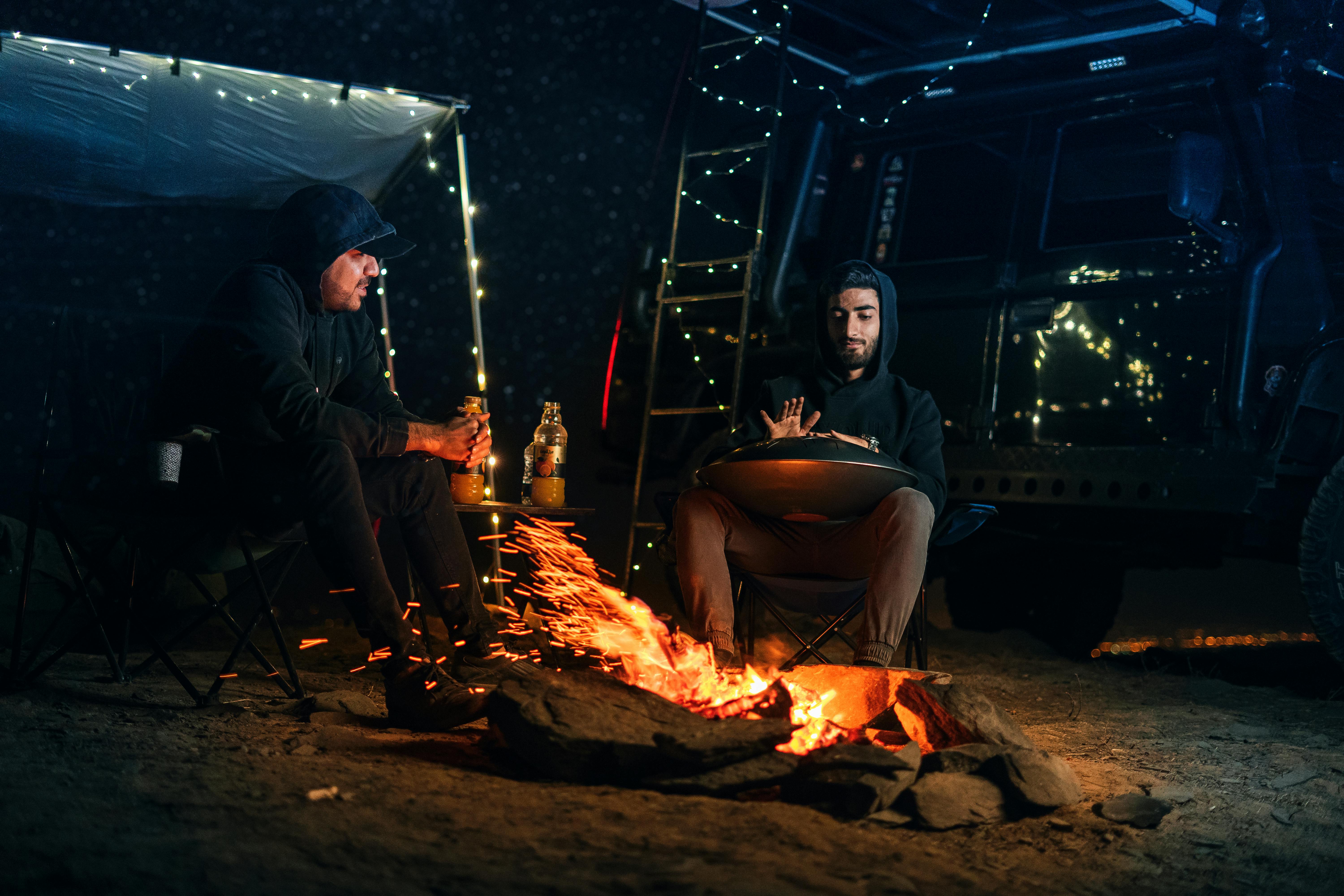 men sitting beside a bonfire