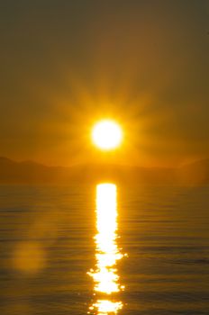 Captivating sunrise reflecting over calm waters in Greece, showcasing golden hues.