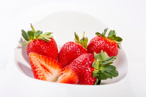 Free Close-up of ripe strawberries in a white bowl, showcasing their vibrant red color and freshness. Stock Photo