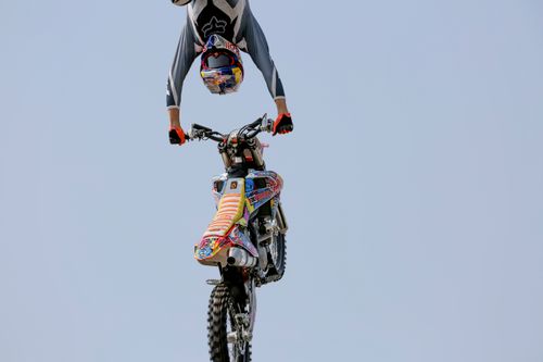 Free A motorcyclist showcases an incredible upside-down stunt in the air, demonstrating extreme skill and control. Stock Photo