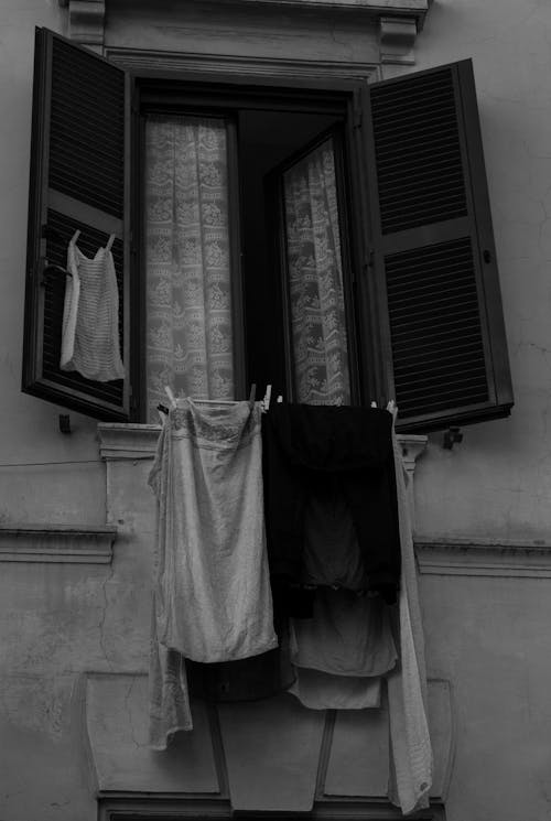 Free Grayscale Photo of Wooden Window with Hanging Cloths  Stock Photo