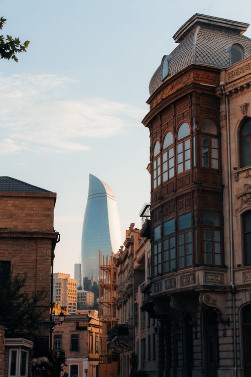 Free Contrast between modern skyscraper and historical architecture at sunset in urban setting. Stock Photo