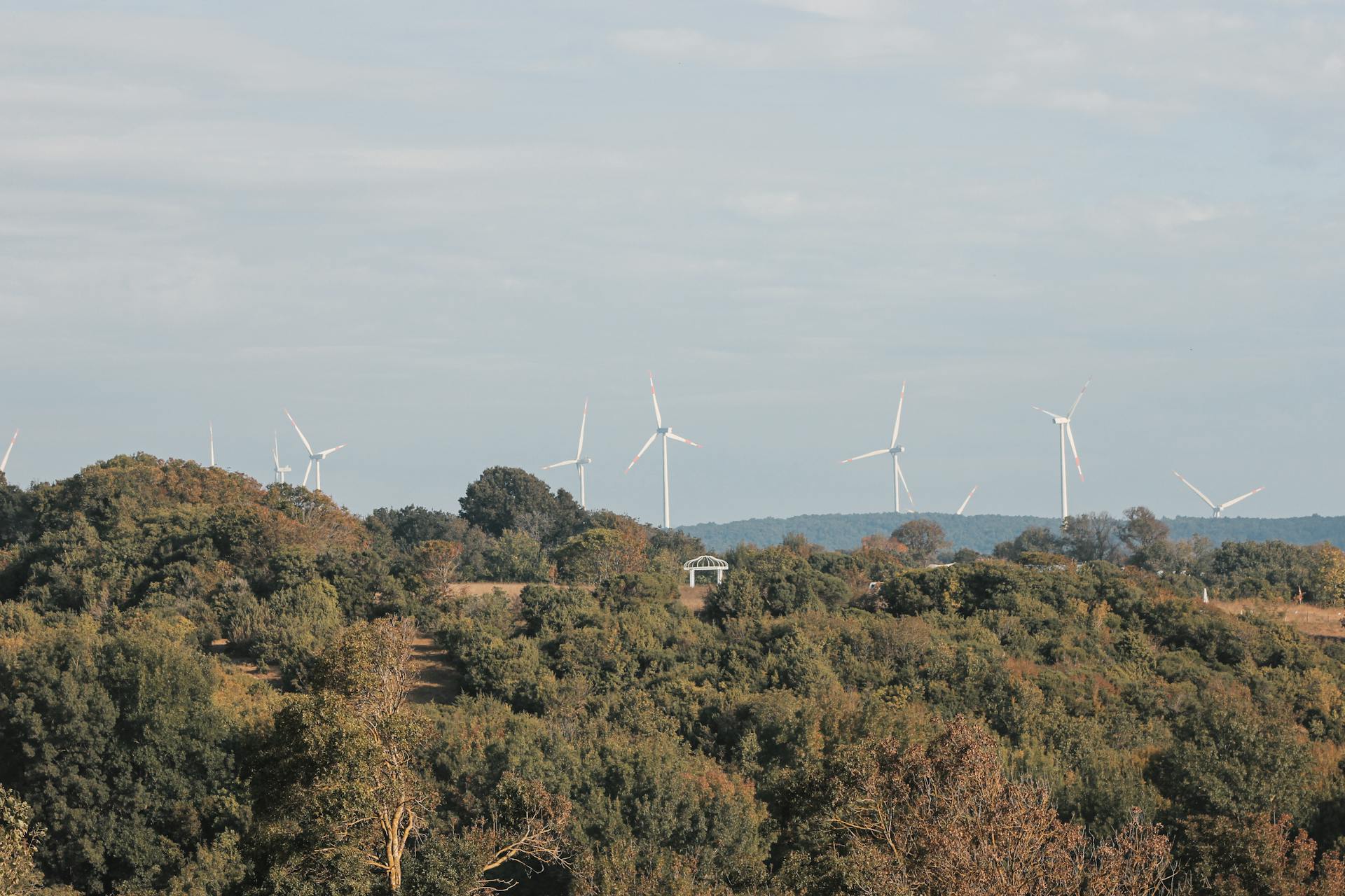 Wind turbines stand tall amidst the green landscape of Kıyıköy, showcasing renewable energy in Türkiye.