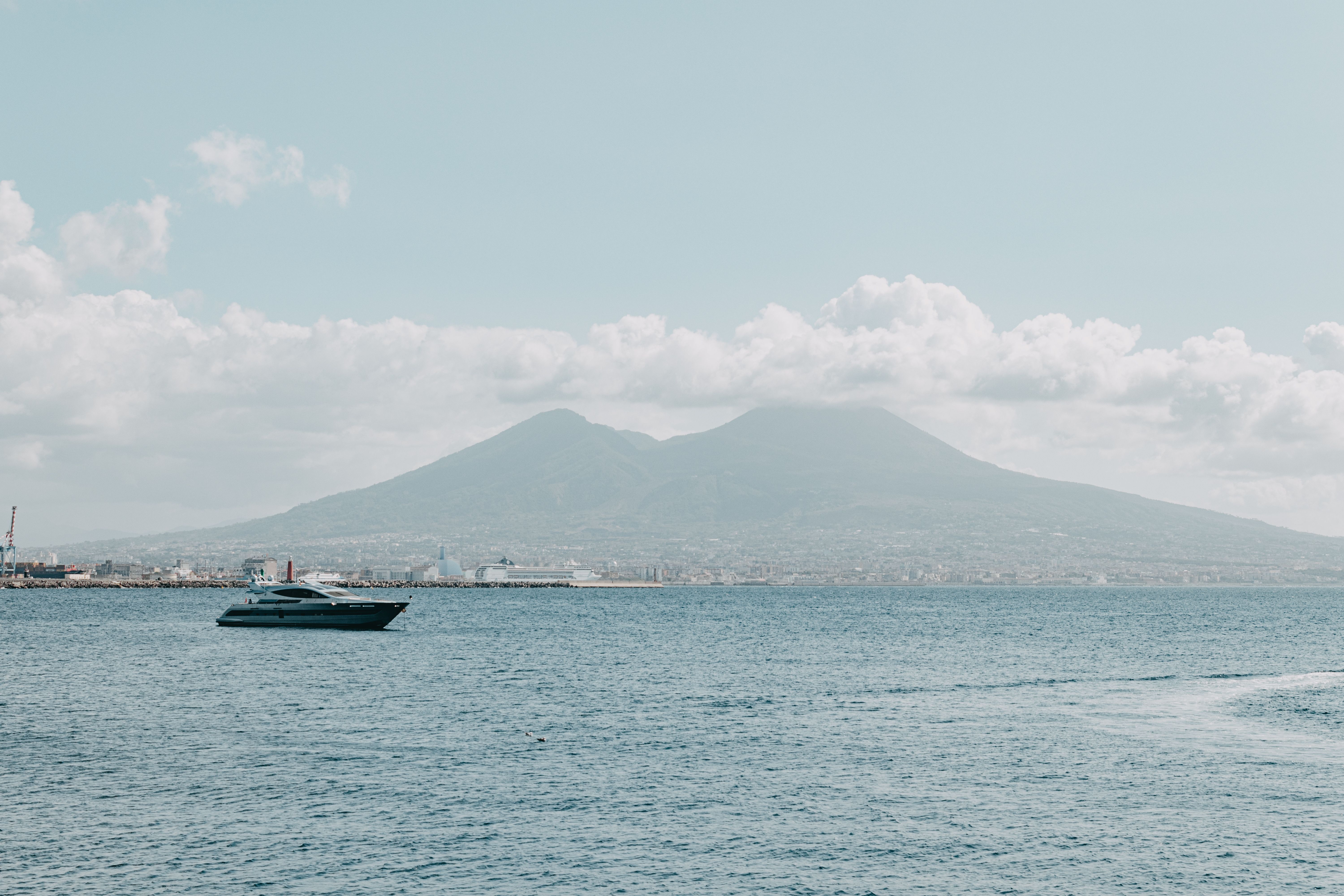Best Boat Tour of Ortigia Island and Sea Caves Review: Syracuse's Best-Kept Secret from the Water Review 2026 - Scenic view of a yacht sailing on the ocean with Mount Vesuvius in the background near Naples, Italy.