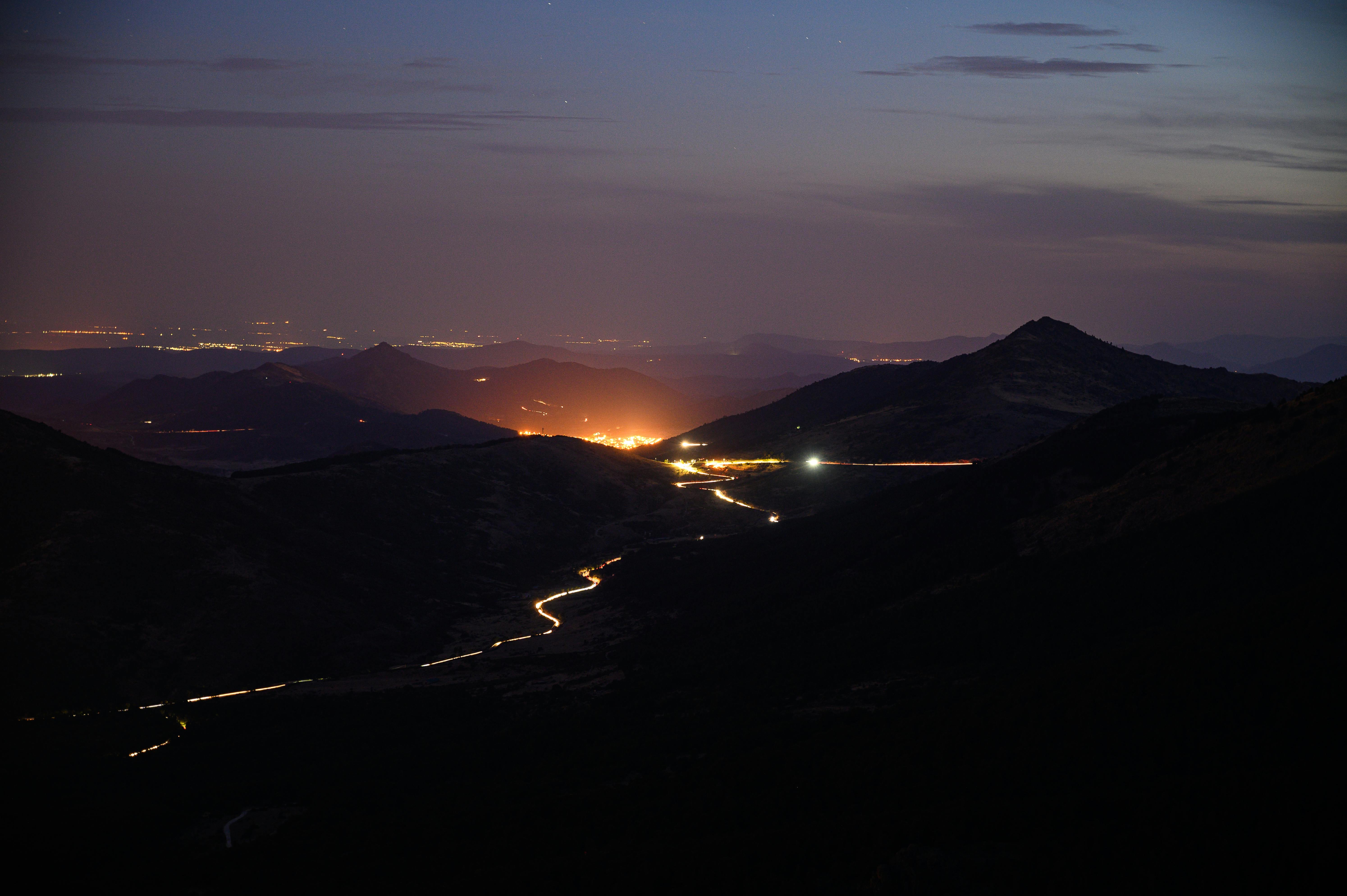 Captivating view of mountains and glowing city lights in Spain during nighttime.