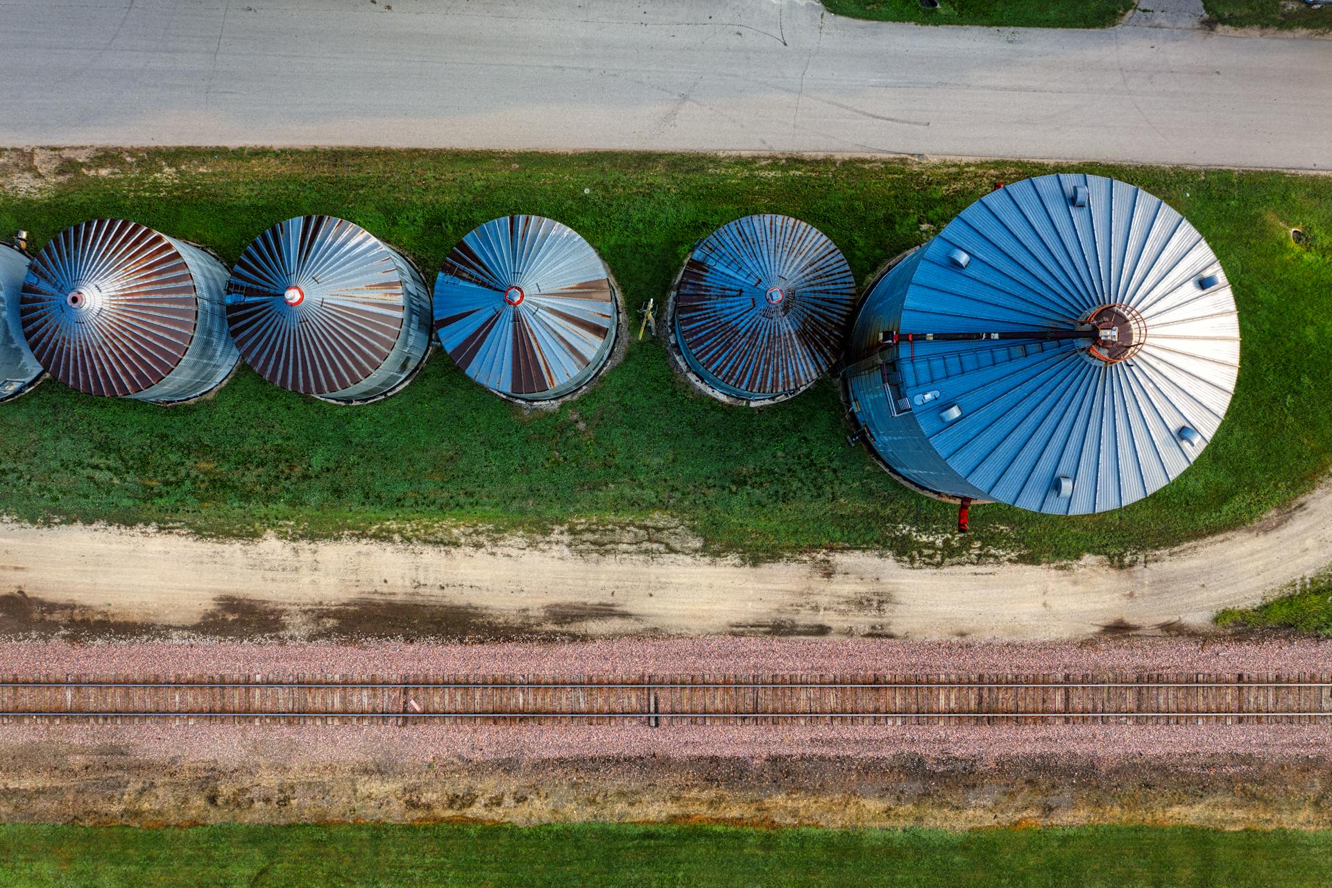 Drone shot of grain silos and railroad in Utica, Minnesota, showcasing agricultural infrastructure.