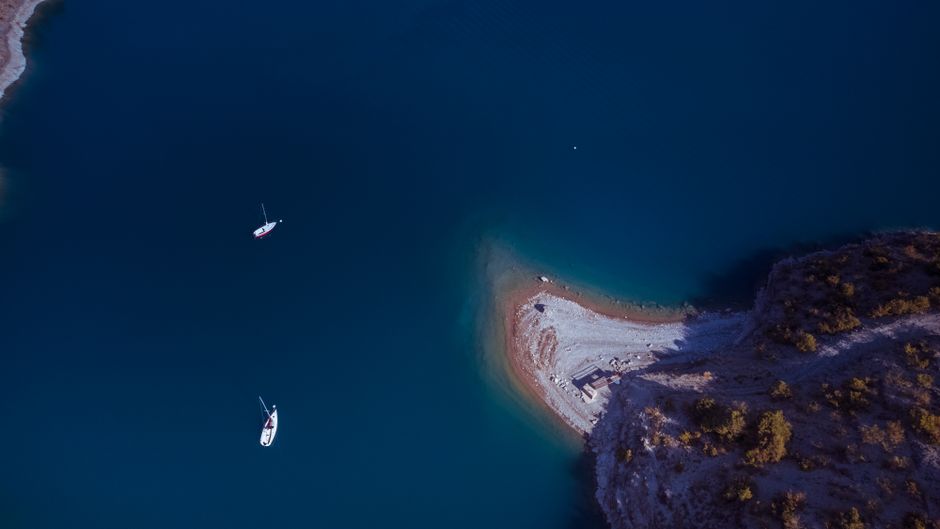 Amazing Antalya Suluada Island Boat Tour Review: Turkey's Hidden Maldives Paradise Review 2026 - A stunning aerial view of boats in azure waters along a rocky coastline.