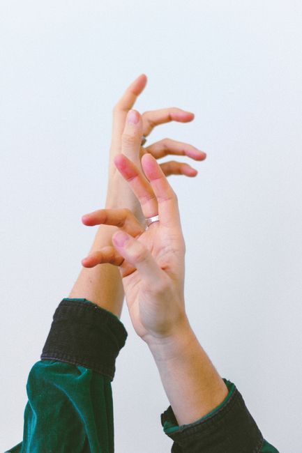 Minimalist close-up of hands with artistic pose on a white background.