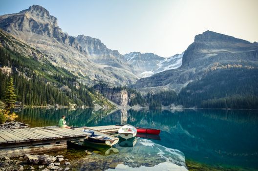 Tranquil Lake O'Hara with boats and mountains in British Columbia, perfect for nature lovers.