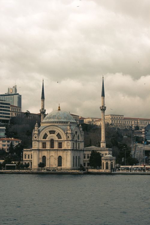 Free Dolmabahçe Mosque by the river in Istanbul, Turkey, under a cloudy sky. Stock Photo