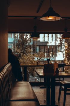 Warm-toned indoor cafe setting with window view of trees and buildings.
