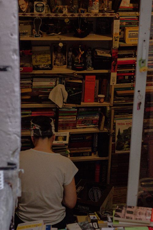 Free A person sits in an Istanbul bookshop surrounded by stacked books and vintage decor. Stock Photo