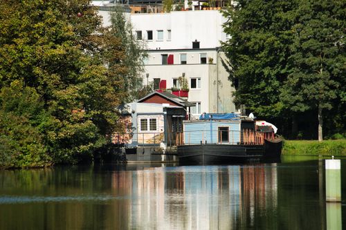 Free Explore a tranquil boathouse setting with calm waters and reflections against lush greenery. Stock Photo