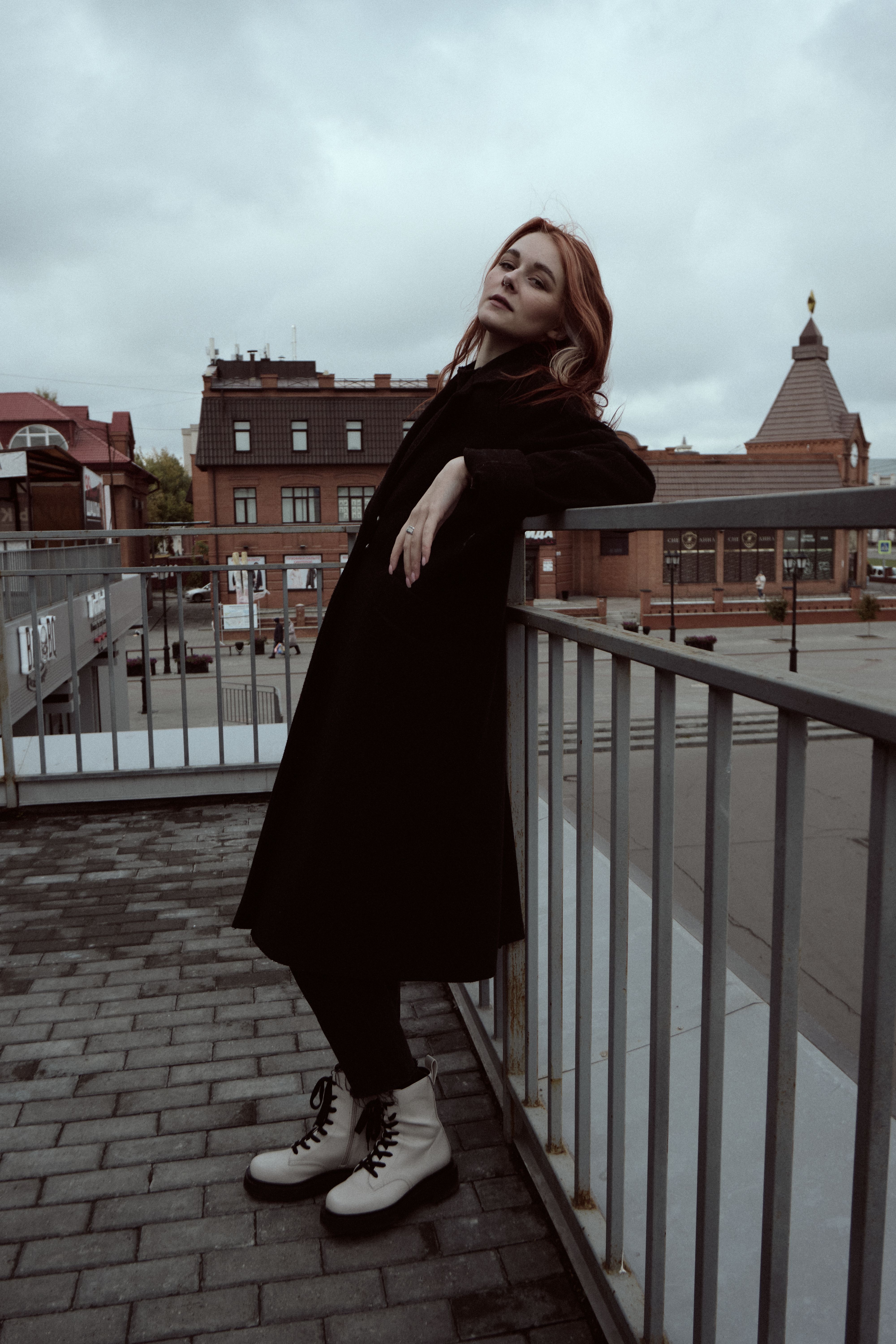 A Woman in Brown Trench Coat Sitting on the Ledge · Free Stock Photo