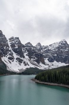 Breathtaking view of Moraine Lake bordered by towering snow-covered Rocky Mountains.