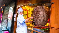Chef in Istanbul preparing shawarma at a street food stall, showcasing vibrant flavors.
