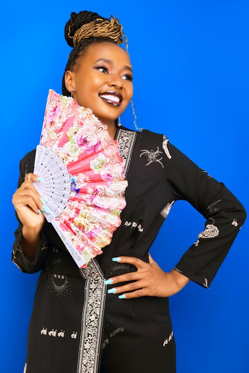 Woman in Traditional Clothing Holding a Hand Fan