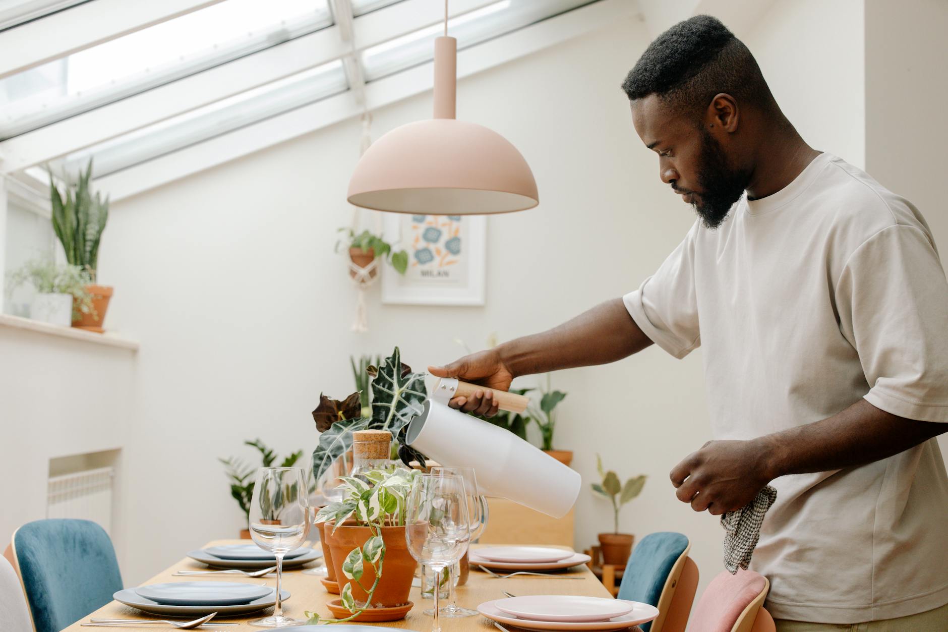 https://www.pexels.com/photo/a-man-watering-the-plant-on-the-dining-table-9720701/