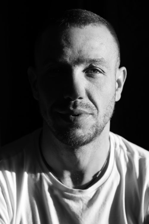 Free Black and white headshot of a smiling man in silhouette lighting. Stock Photo