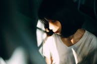 柔和灯光下的阴影中，一位女子喜怒无常的肖像传达了深刻的思考