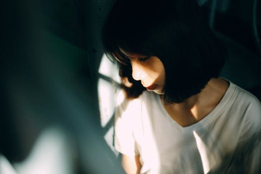 柔和灯光下的阴影中，一位女子喜怒无常的肖像传达了深刻的思考