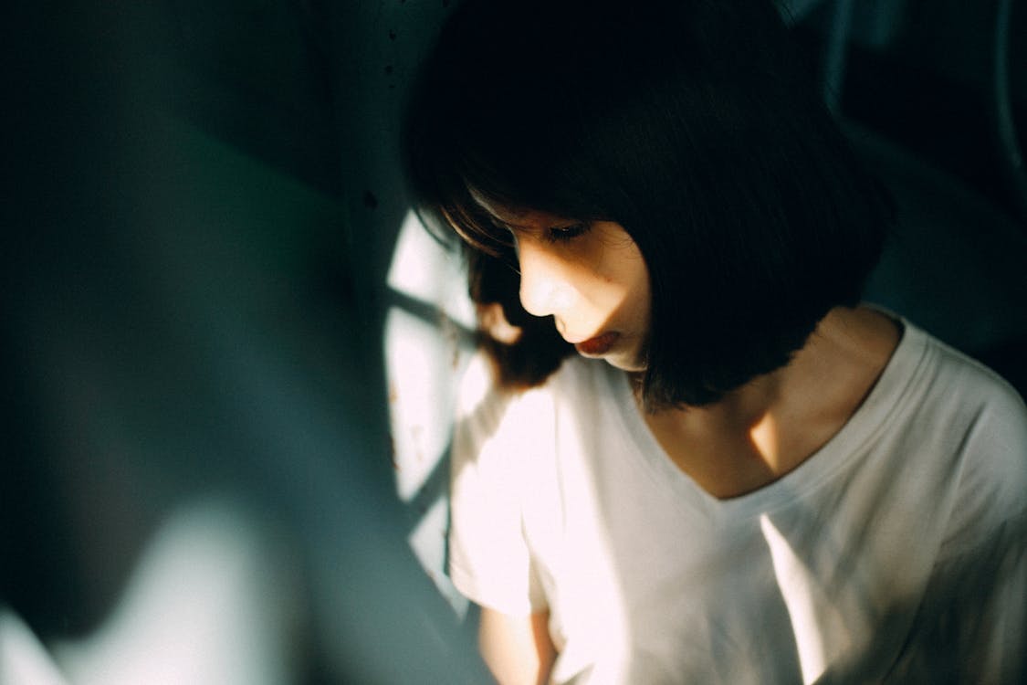 Mujer Vistiendo Camiseta Blanca Con Cuello En V, Apoyado En La Pared Blanca