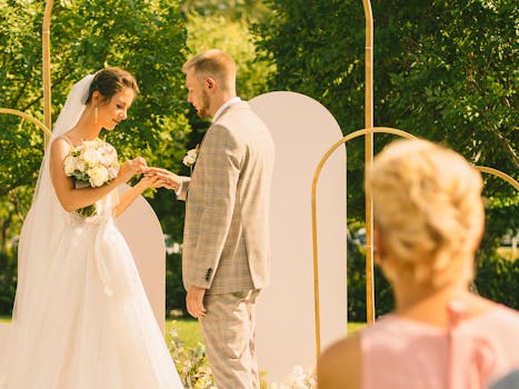 Bride and groom exchange rings during a beautiful outdoor wedding ceremony.