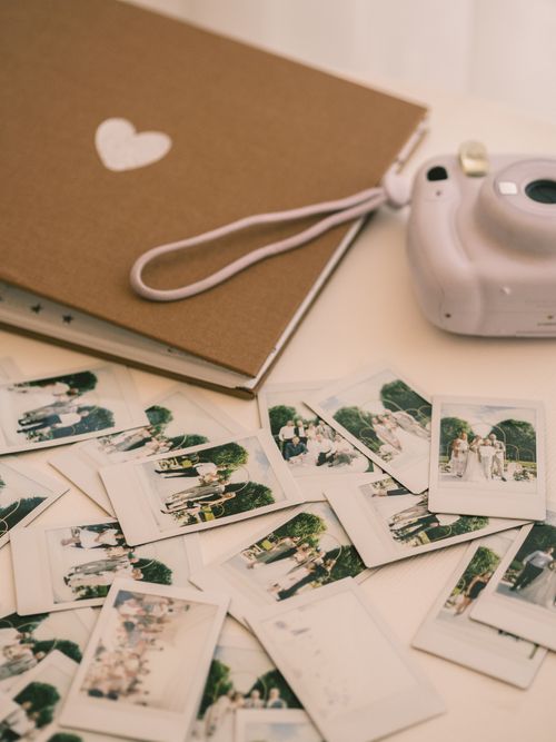 Free A collection of polaroid photos scattered with an instant camera and album on a white surface. Stock Photo