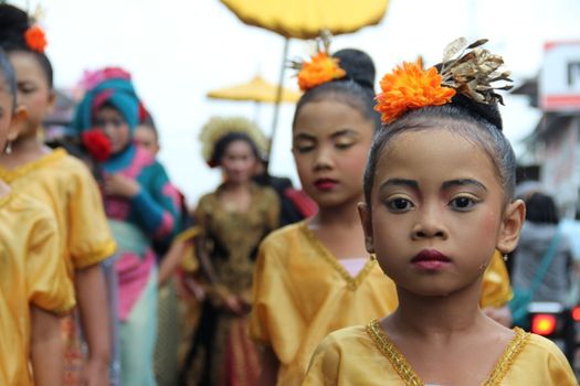 Young girls in traditional attire participate in a cultural parade in Kopang, Indonesia.