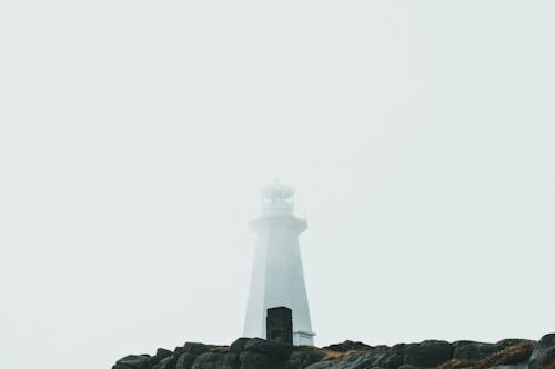 White Lighthouse Tower on Rocky Coast