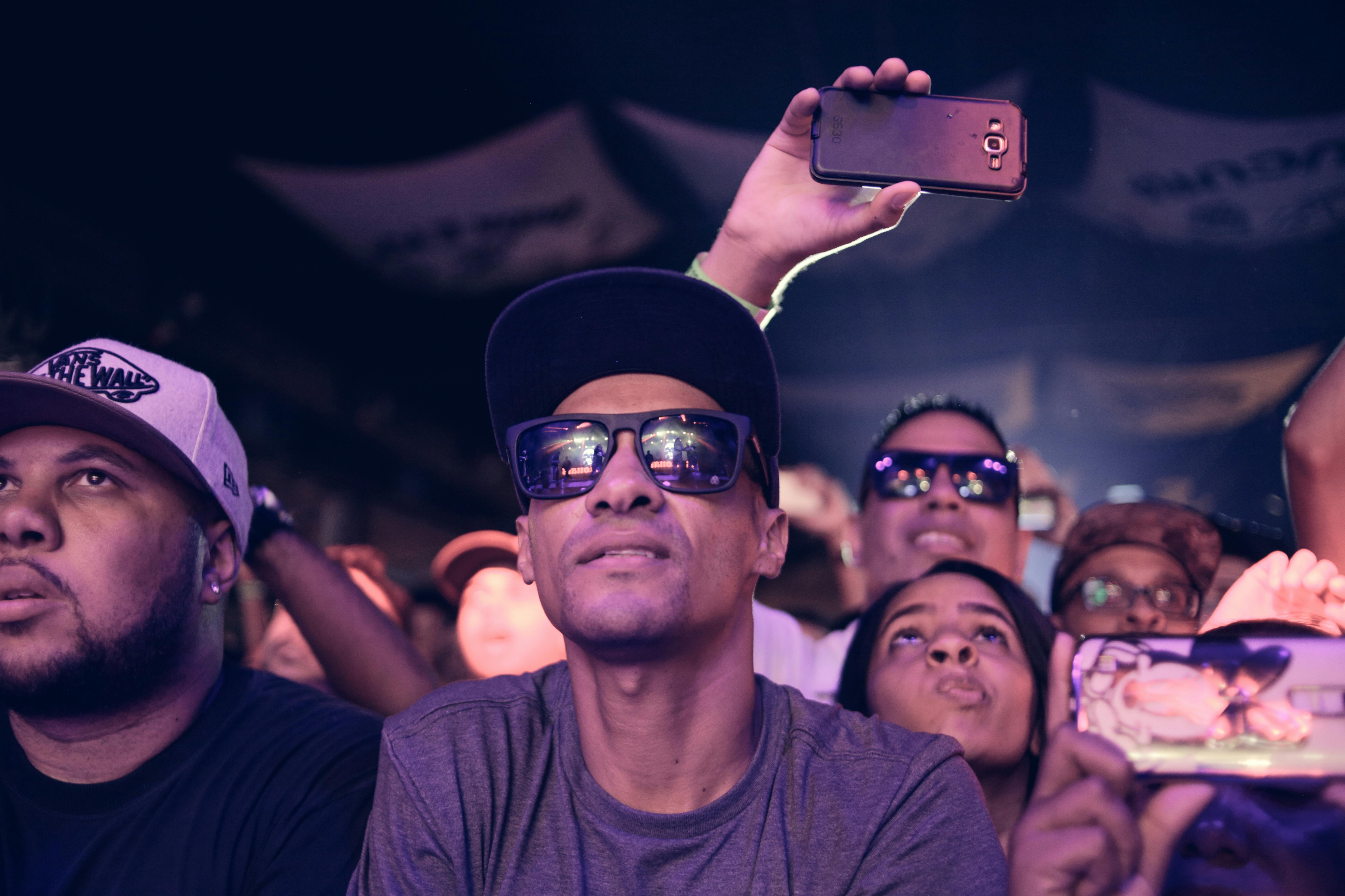 man wearing black sunglasses sitting next to man