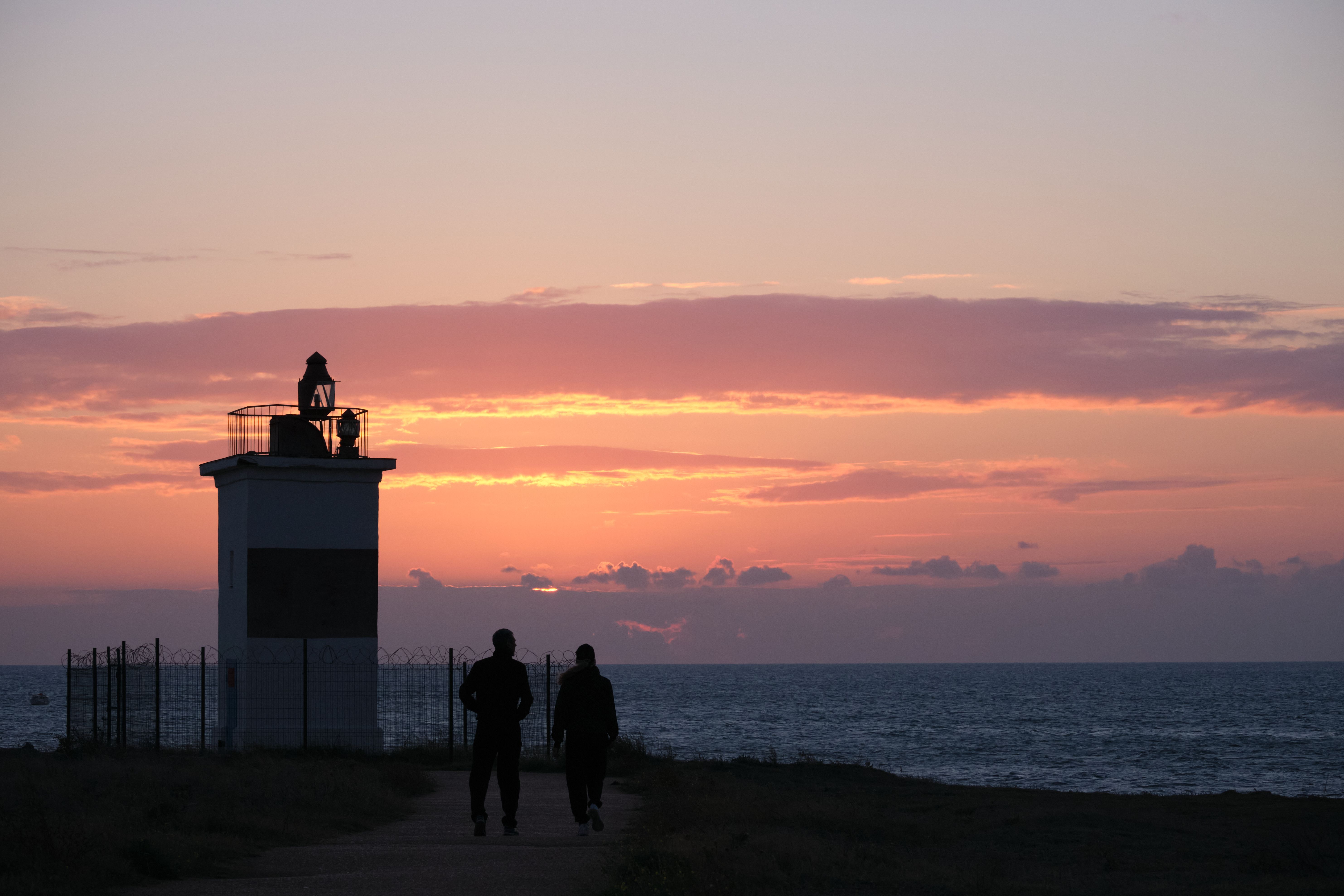 Silhouette of People Standing on Seashore during Sunset · Free Stock Photo
