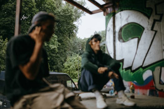 Street style scene of two young adults by vibrant graffiti art, showcasing urban lifestyle.