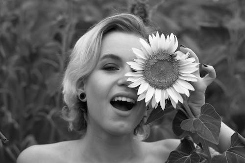 Free Grayscale Photo of Woman Holding a Flower near her Eye Stock Photo