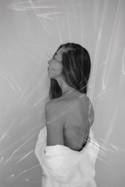 Artistic black and white portrait of a woman with long hair, captured in a studio setting.