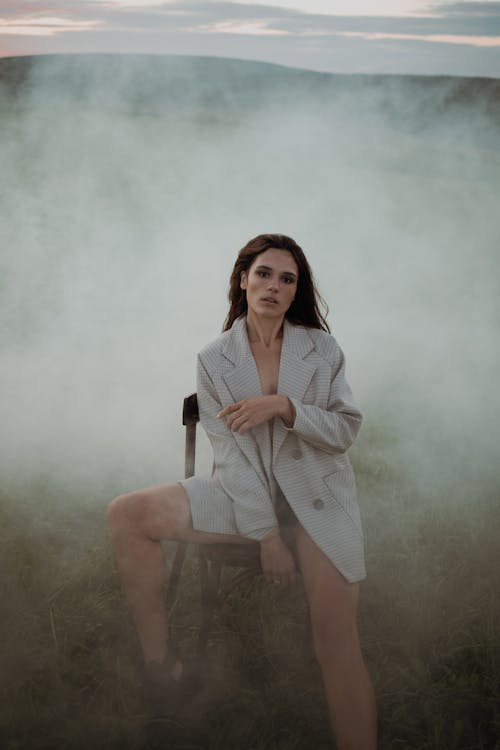 Young woman wearing checkered jacket and posing in smoke