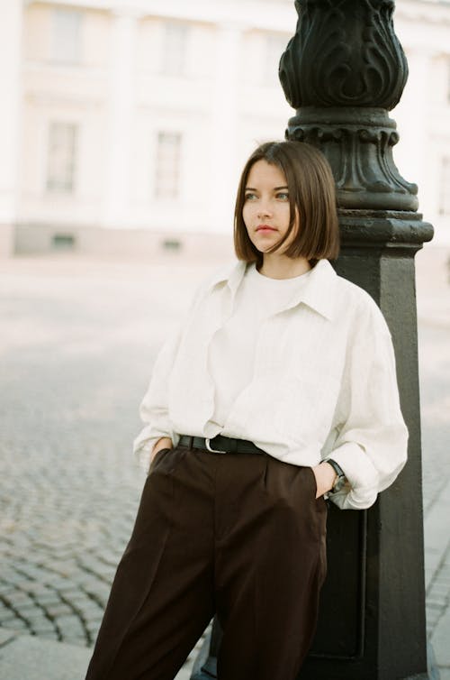Free Photo of a Woman Wearing a White Shirt and Brown Pants Stock Photo