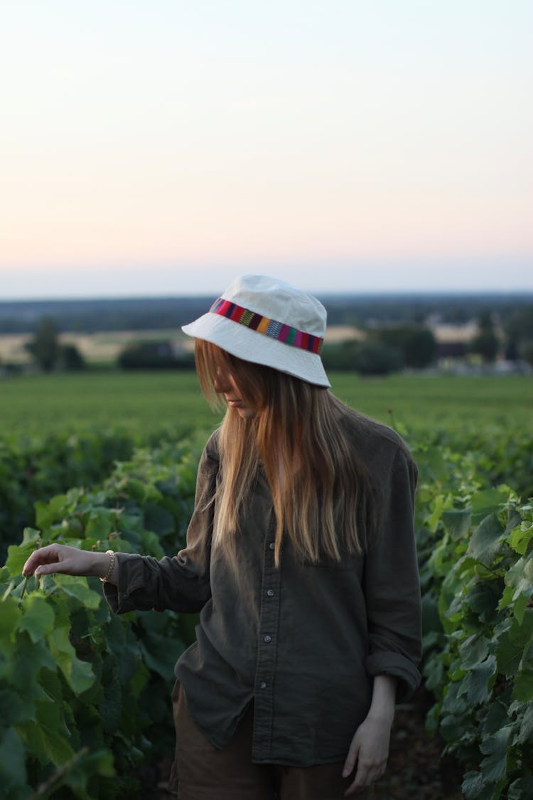 Girl Wearing A Sun Hat Standing In A Vineyard