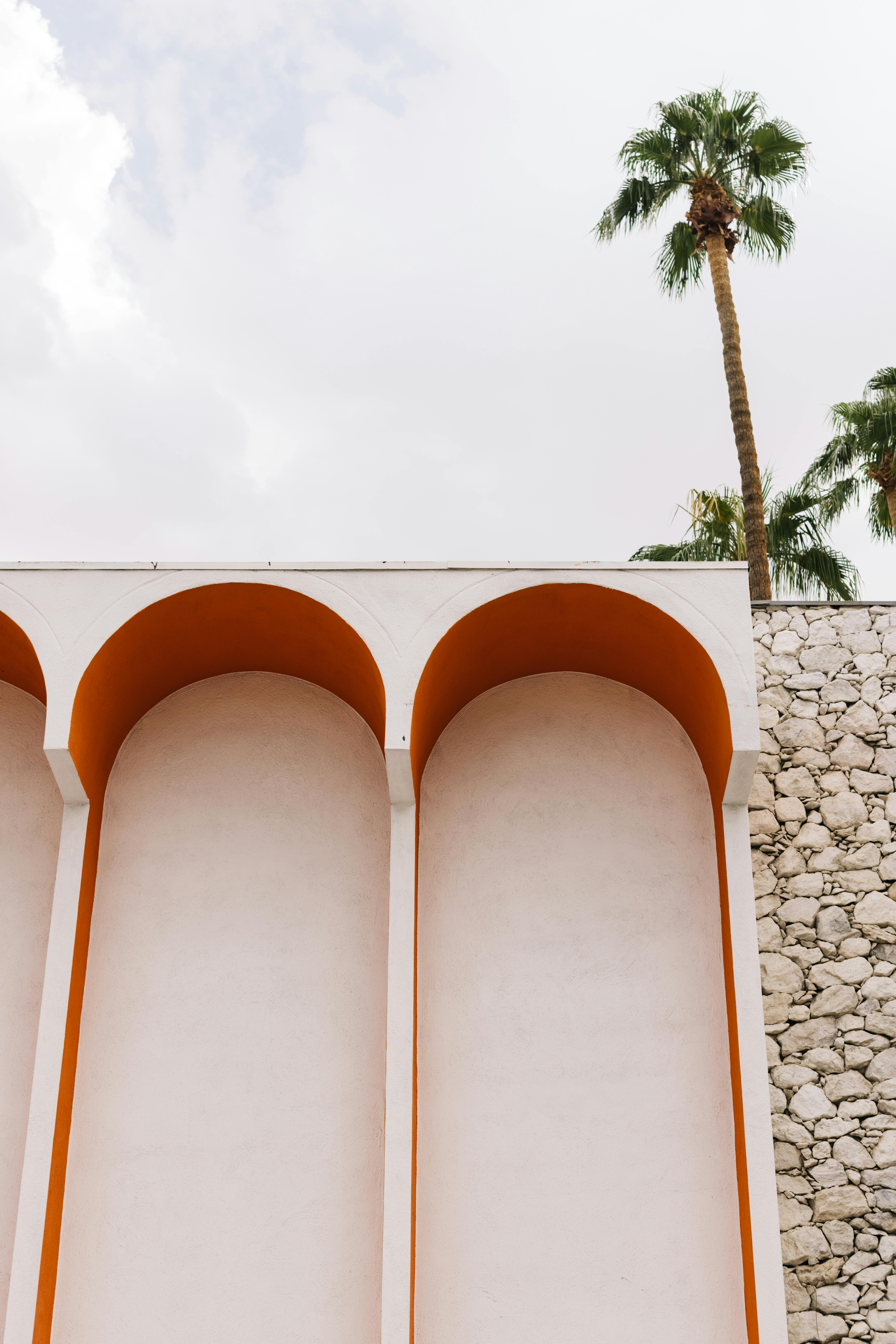 Elegant building arches with palm trees in Palm Springs. Bright and architectural.