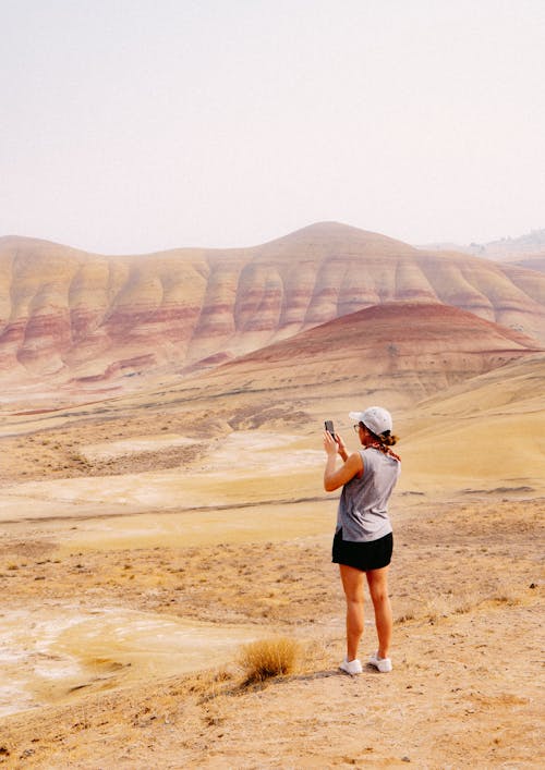 Female Tourist Photographing Barren Hills