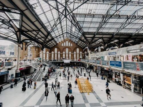 Free A busy interior view of a modern train station with a glass ceiling and people commuting. Stock Photo