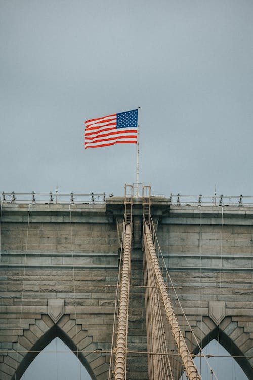 Flag of Us a on Top of Gray Concrete Bridge