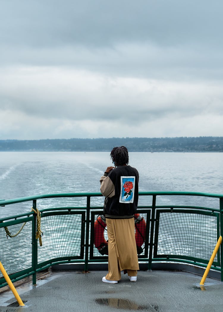 Person Standing Near The Ship Railings 