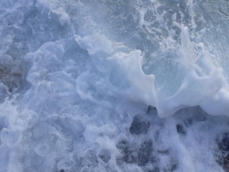 Close-up of ocean waves with foam and bubbles, captured in Ula, Turkey.