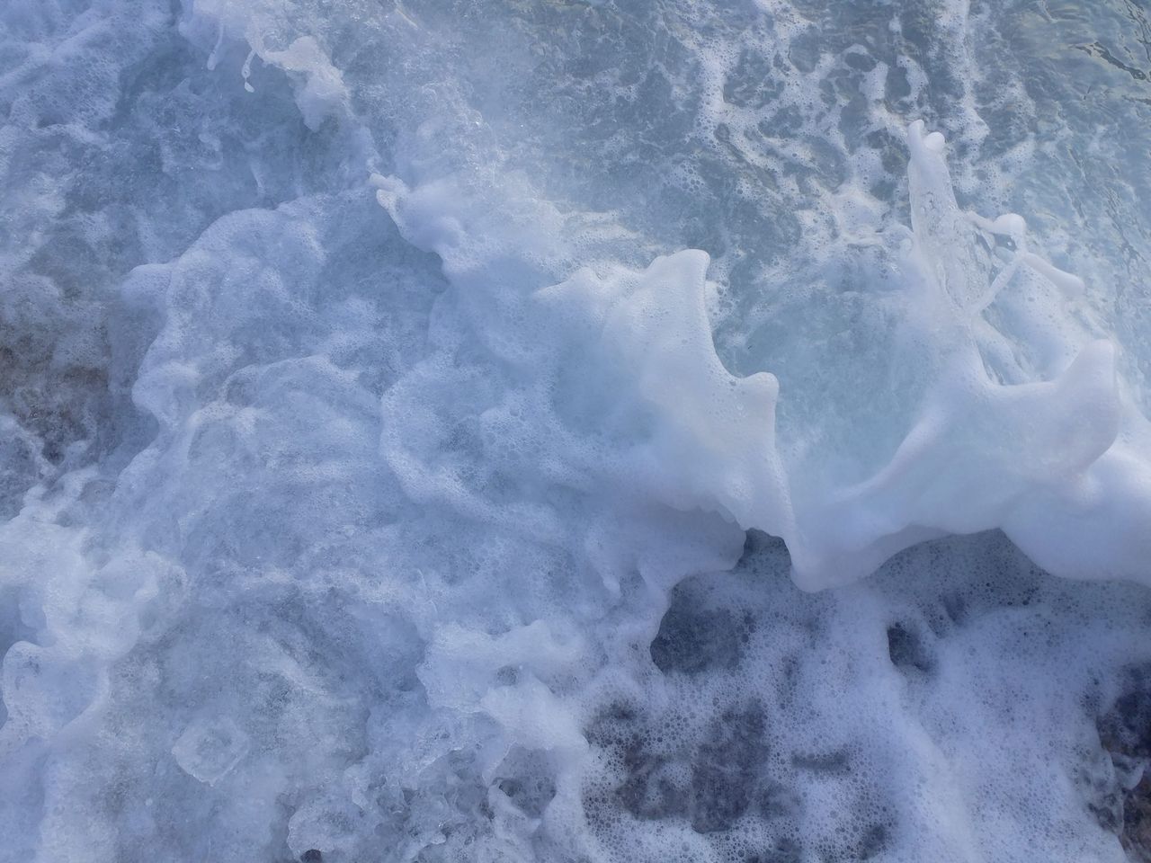 close up of ocean waves with foam and bubbles captured in ula turkey