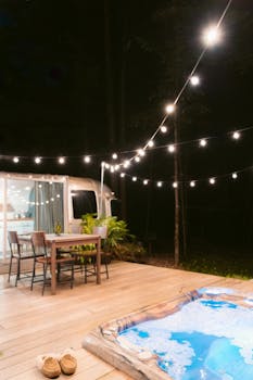 Warm-lit outdoor setup with a jacuzzi and camper, ideal for relaxation.