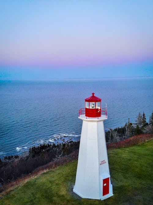 White and Red Lighthouse Near Body of Water