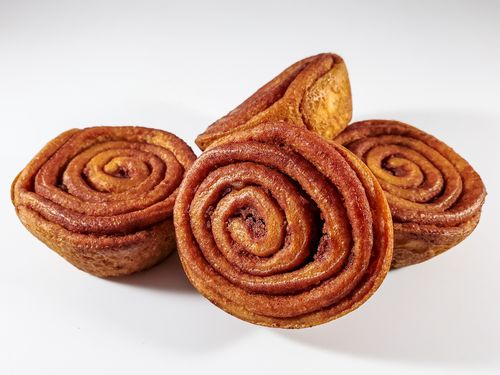 Free Close-up of freshly baked cinnamon rolls showcasing their spiral shape and golden-brown crust. Stock Photo