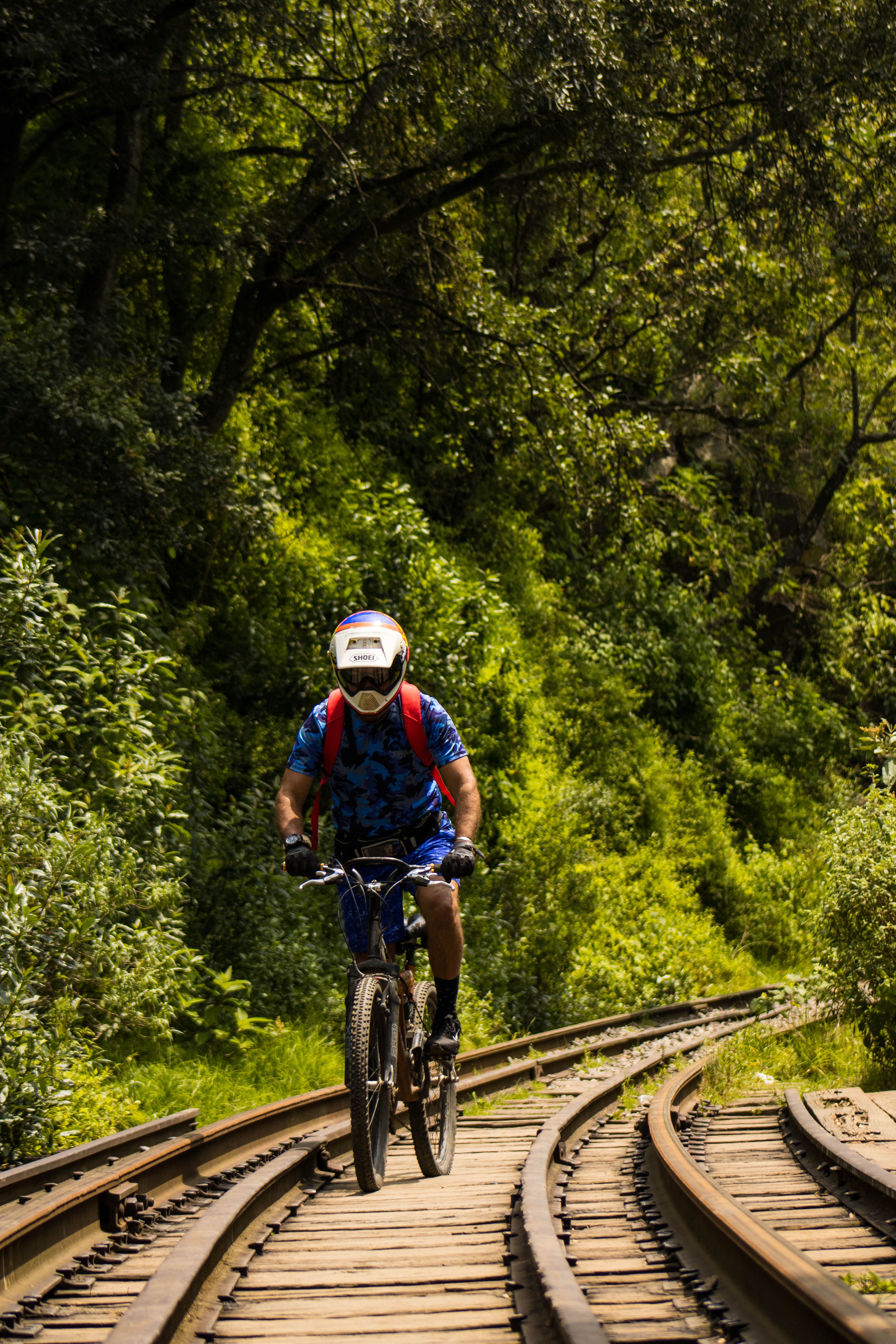A Person Riding a Bicycle on a Railroad · Free Stock Photo