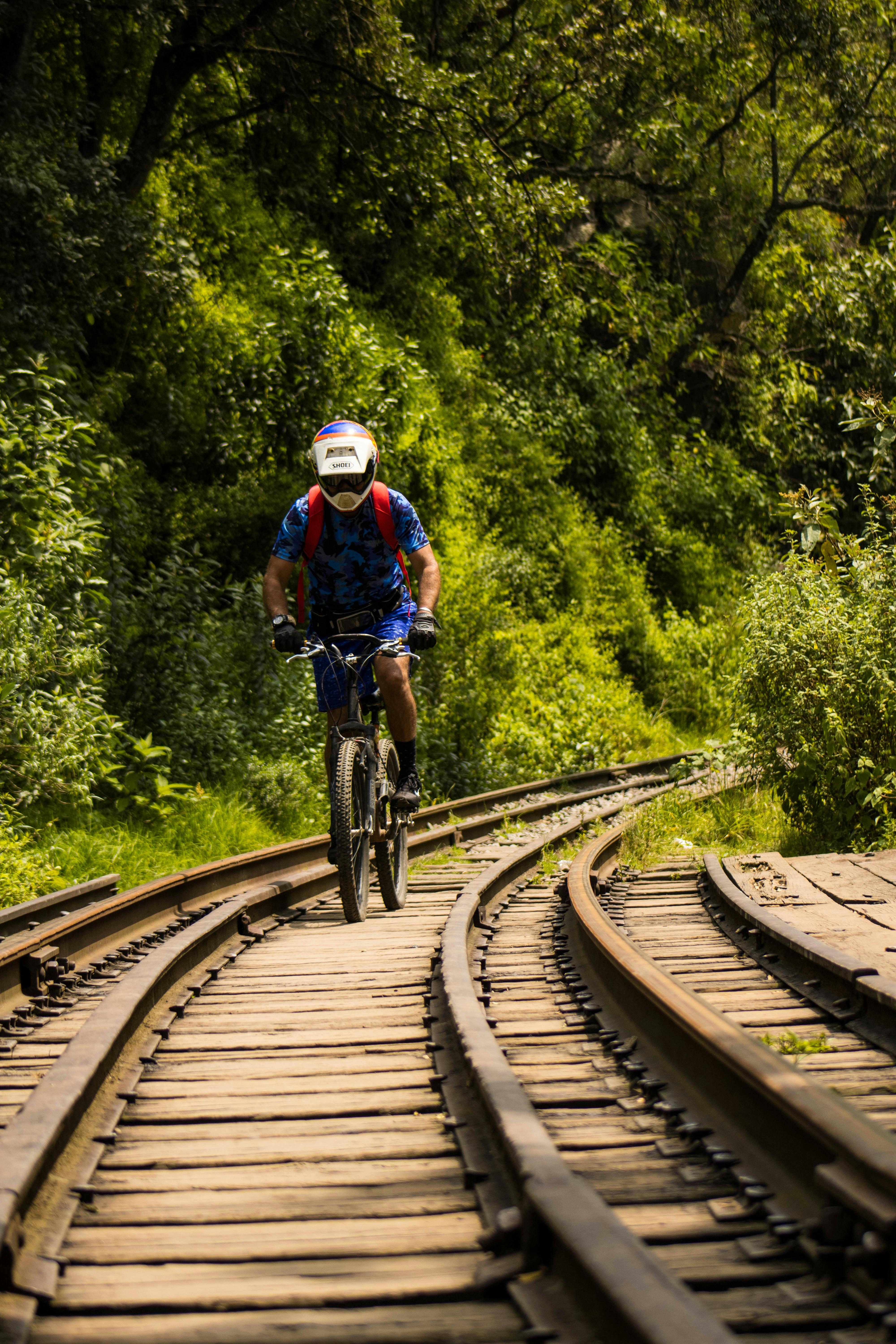 A Person Riding a Bicycle on a Railroad · Free Stock Photo